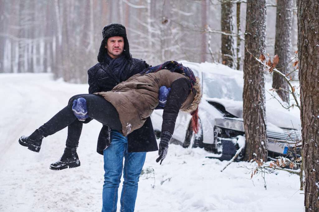 after car crush winter forest confident serious man is holding injured woman 1 1024x683 1